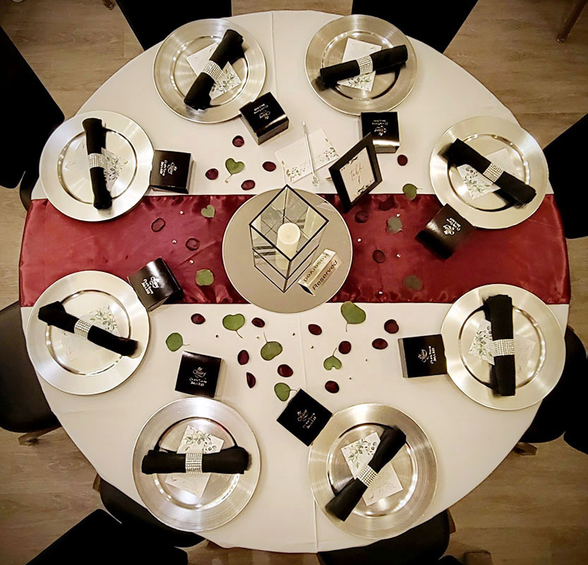Round table with settings and flower petals